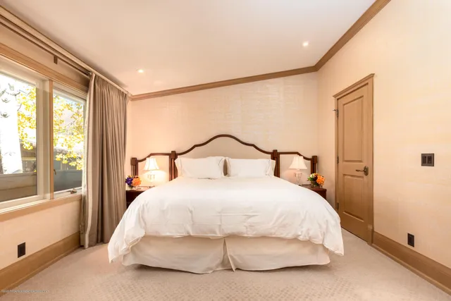 a bedroom with a bed and large window