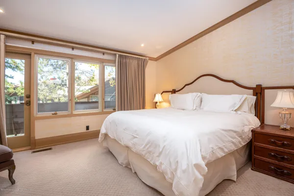 a bedroom with a bed and a large window