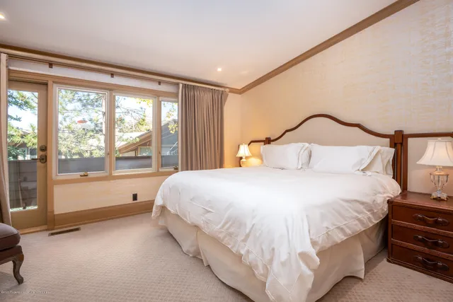 a bedroom with a bed and a large window