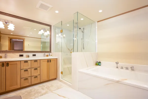 a bathroom with a double vanity sink mirror and bathtub