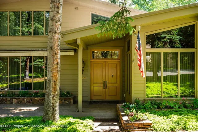 a living room with furniture a fireplace and large windows