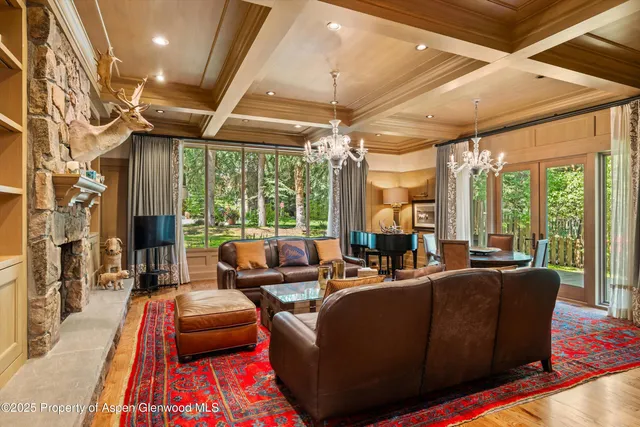 a living room with fireplace furniture and a chandelier