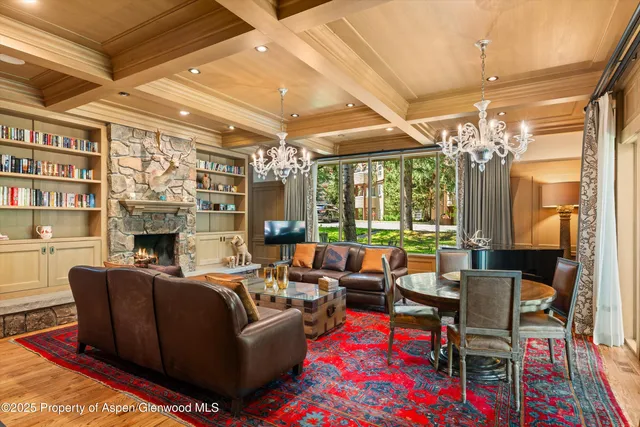 a living room with furniture a fireplace and a chandelier