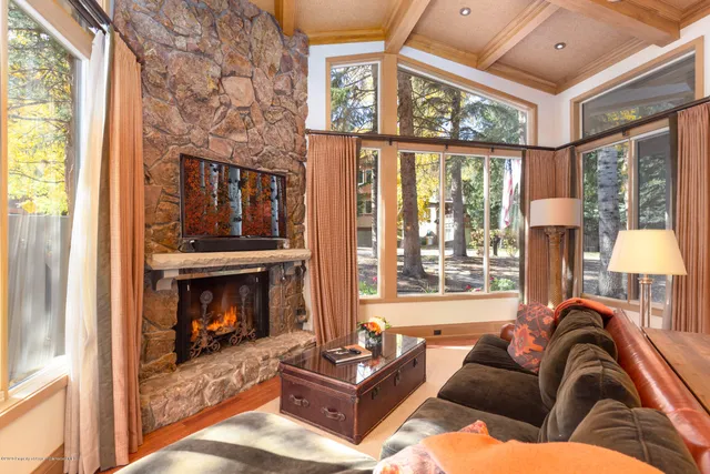 a living room with furniture a large window and a fireplace