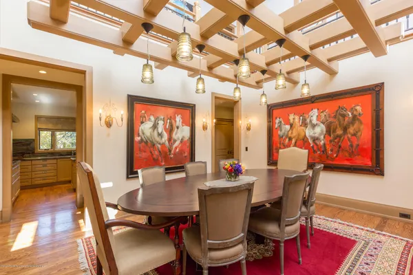 a view of a dining room with furniture a chandelier and wooden floor