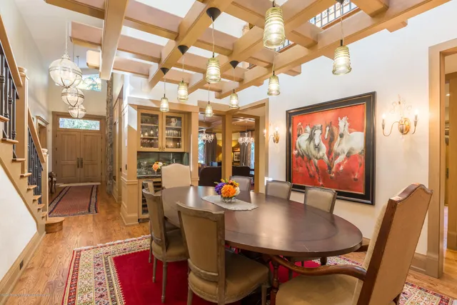 a dining room with furniture a floor to ceiling window and wooden floor