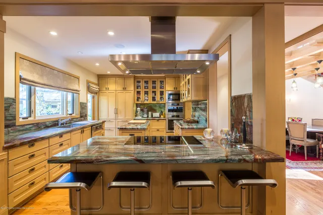 a kitchen with a sink and chairs