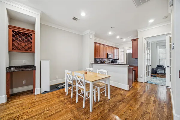 a living room with stainless steel appliances kitchen island granite countertop furniture and a wooden floor