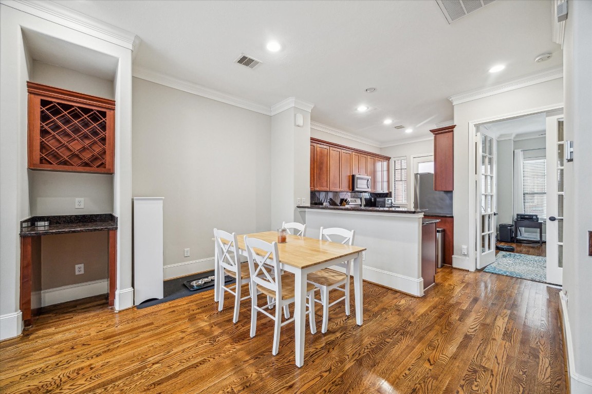 1046 West 23rd Street, Unit C Houston, TX 77008 - Photo 5 of 15 a living room with stainless steel appliances kitchen island granite countertop furniture and a wooden floor