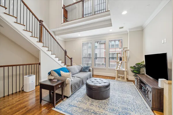 a living room with furniture a flat screen tv and a floor to ceiling window