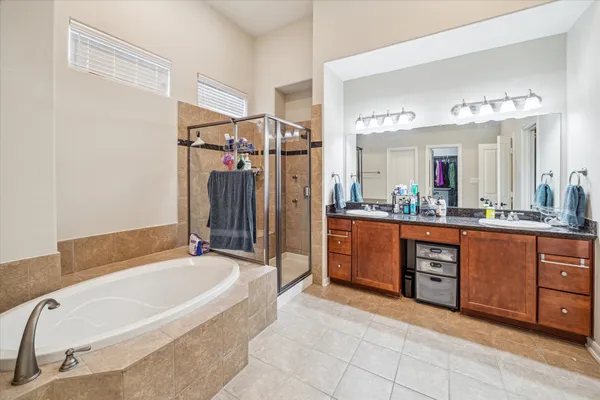 a spacious bathroom with a tub sink and mirror