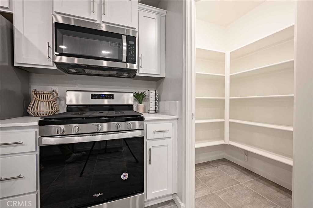 4723 Jema Way, Unit 8 B1 Merced, CA 95348 - Photo 5 of 18 a kitchen with stainless steel appliances granite countertop a stove microwave and oven