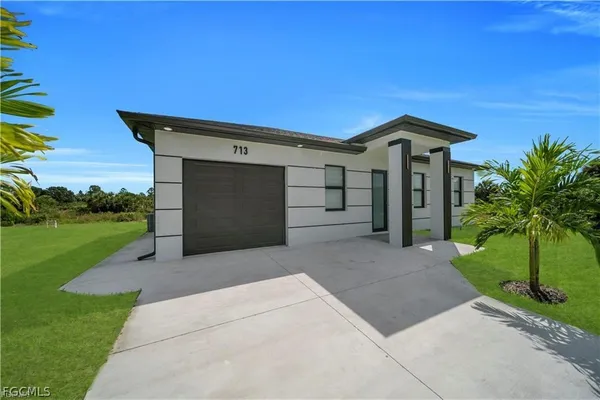 a front view of a house with a yard and garage