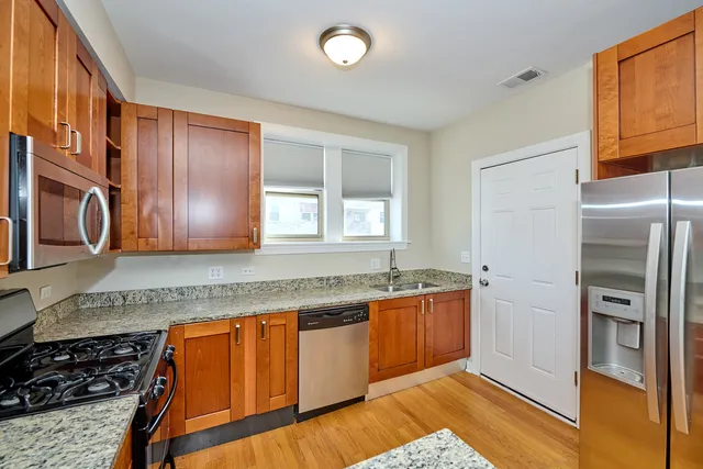 a kitchen with stainless steel appliances granite countertop a refrigerator and a sink