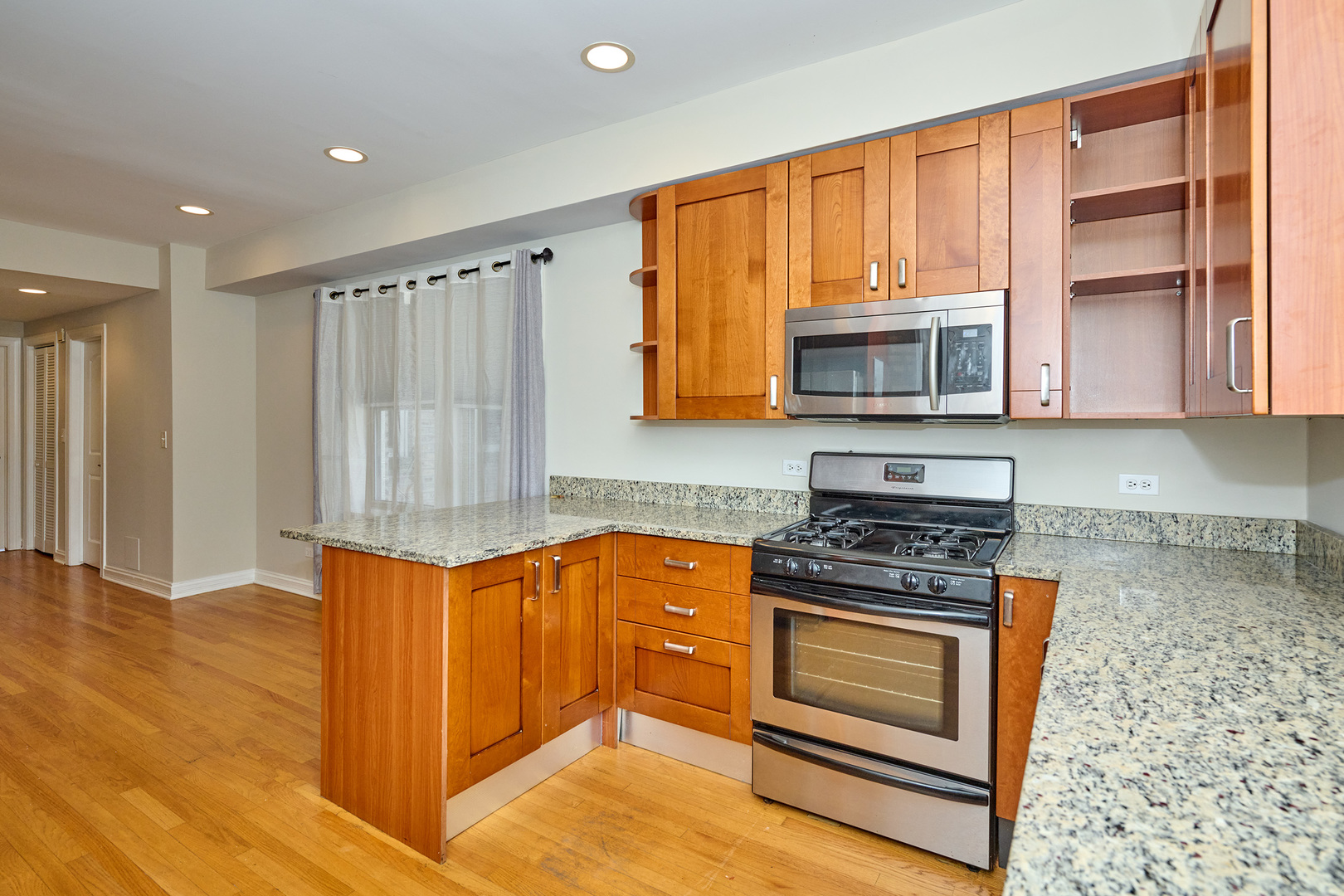 5715 North Kimball Avenue, Unit 1N Chicago, IL 60659 - Photo 12 of 36 a kitchen with wooden cabinets and a stove top oven