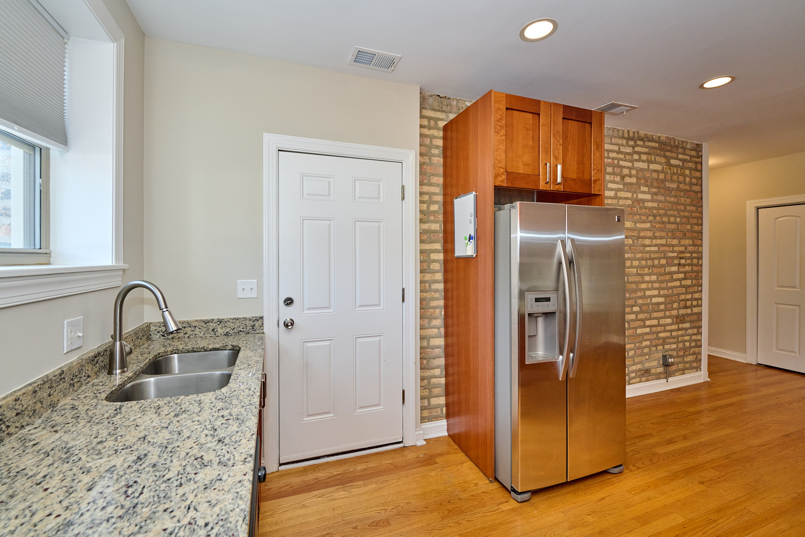 5715 North Kimball Avenue, Unit 1N Chicago, IL 60659 - Photo 13 of 36 a kitchen with stainless steel appliances granite countertop a refrigerator and a sink