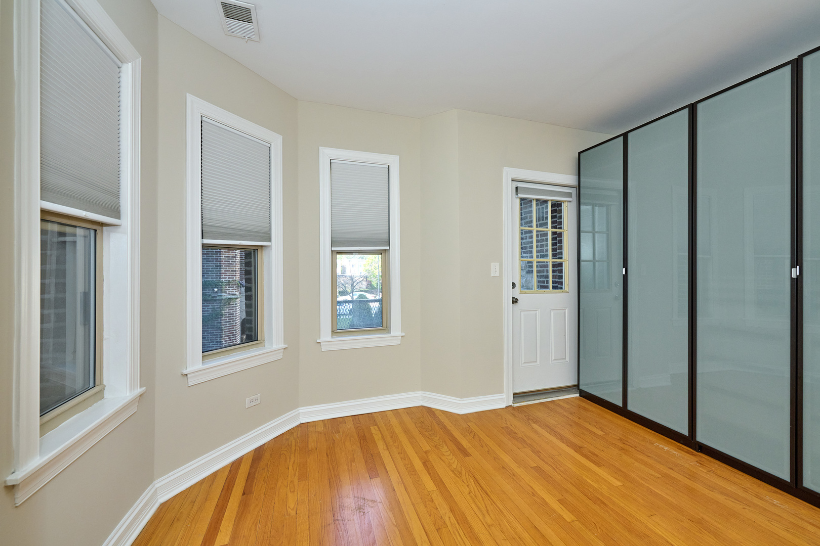 5715 North Kimball Avenue, Unit 1N Chicago, IL 60659 - Photo 19 of 36 a view of an empty room with wooden floor and a window