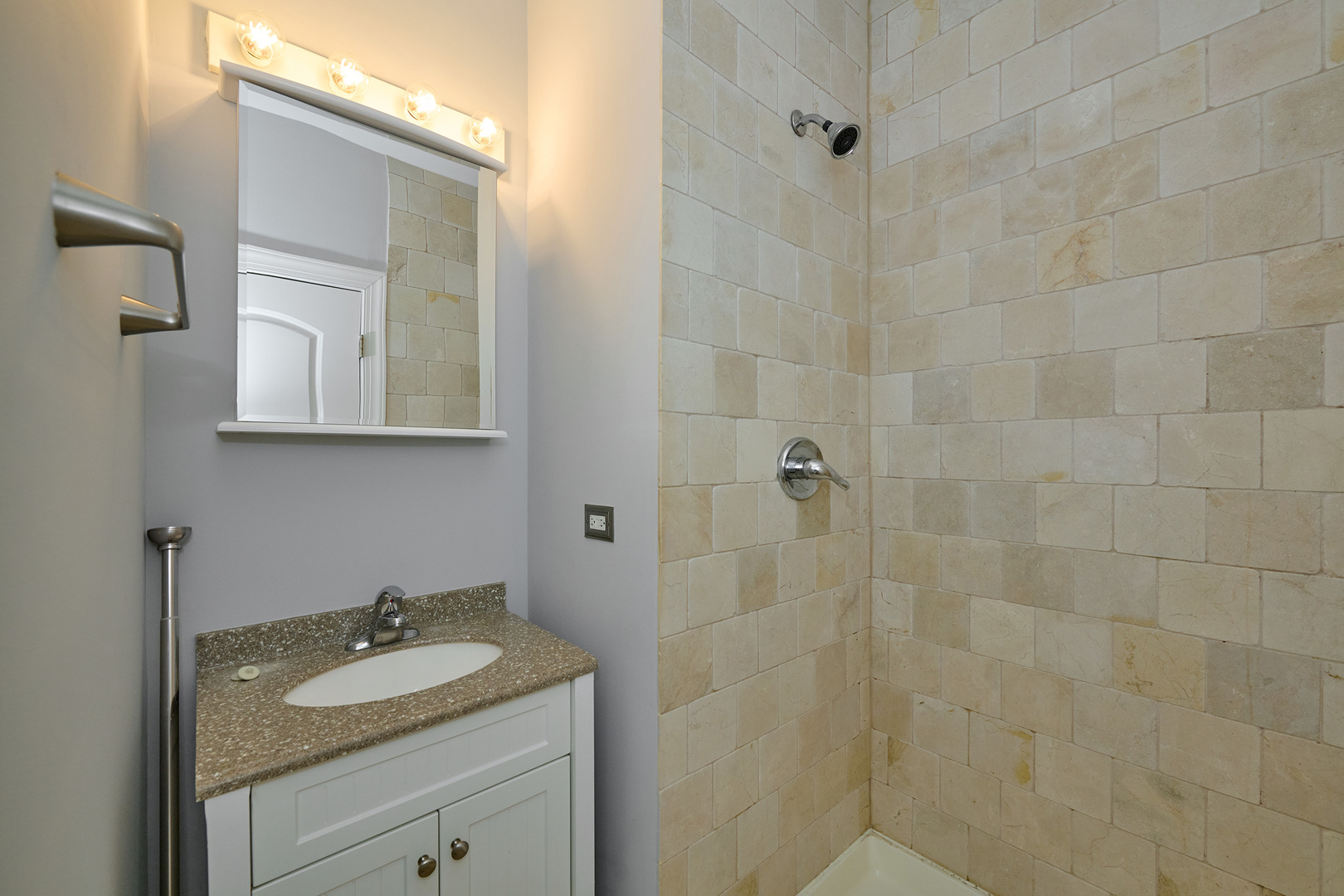 5715 North Kimball Avenue, Unit 1N Chicago, IL 60659 - Photo 21 of 36 a bathroom with a granite countertop sink a mirror and shower