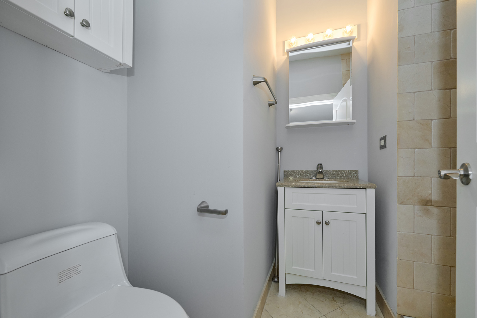 5715 North Kimball Avenue, Unit 1N Chicago, IL 60659 - Photo 22 of 36 a bathroom with a toilet sink and mirror