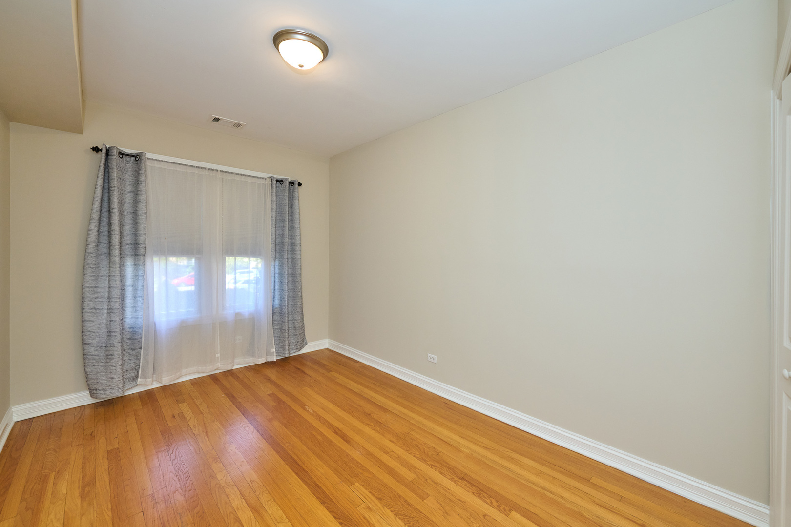 5715 North Kimball Avenue, Unit 1N Chicago, IL 60659 - Photo 24 of 36 an empty room with wooden floor and windows