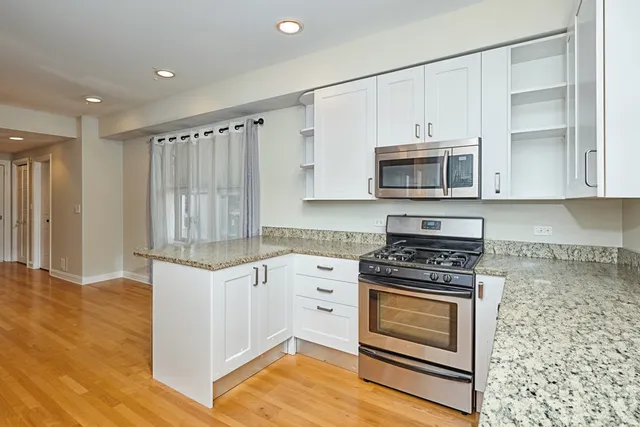 a kitchen with stainless steel appliances granite countertop a refrigerator and a sink