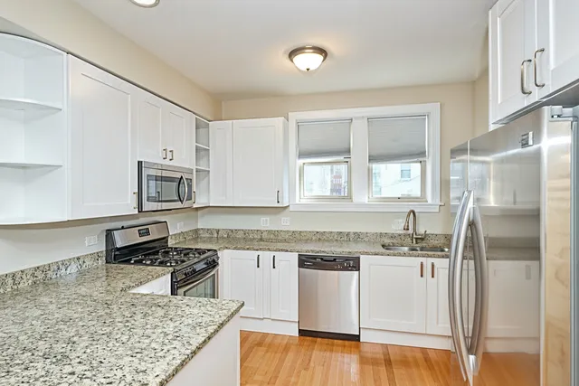 a view of a kitchen with a sink and a refrigerator