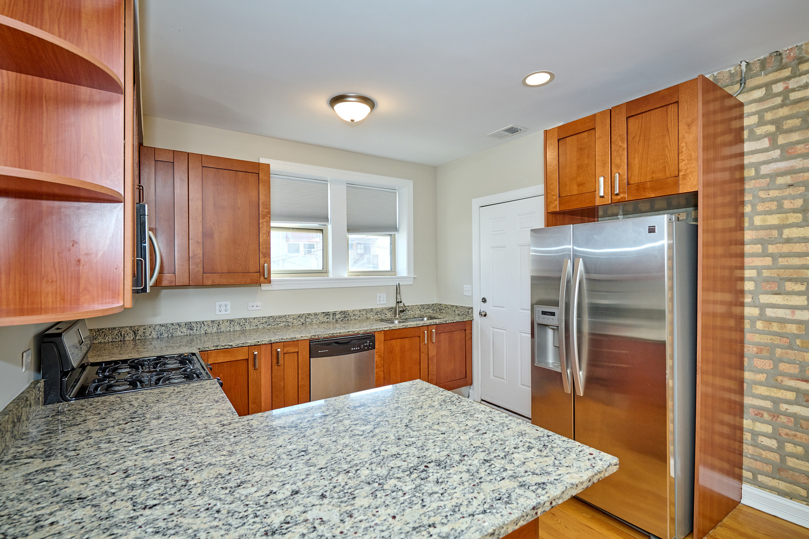 5715 North Kimball Avenue, Unit 1N Chicago, IL 60659 - Photo 9 of 36 a kitchen with stainless steel appliances granite countertop a sink stove and refrigerator