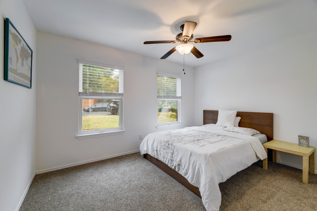 6002 Baton Rouge Drive Austin, TX 78727 - Photo 15 of 20 Bright room featuring white walls, two windows with blinds, a ceiling fan with integrated lighting, and carpeted flooring