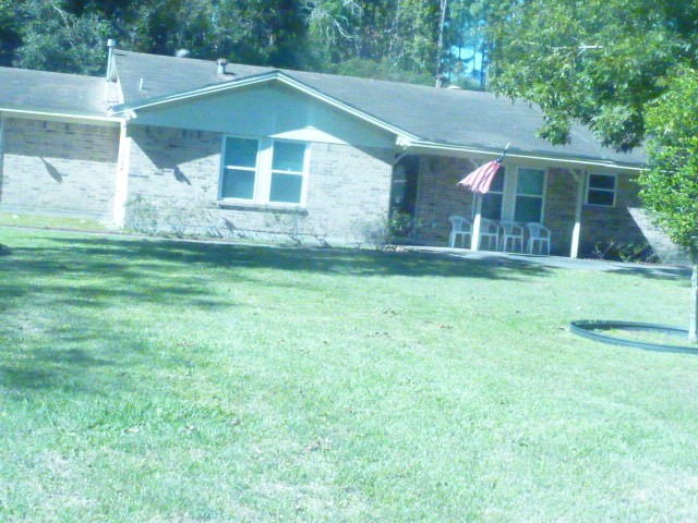 3978 Highway 59 Cleveland, TX 77328 - Photo 2 of 20 a view of a yard in front of a house with plants and large tree