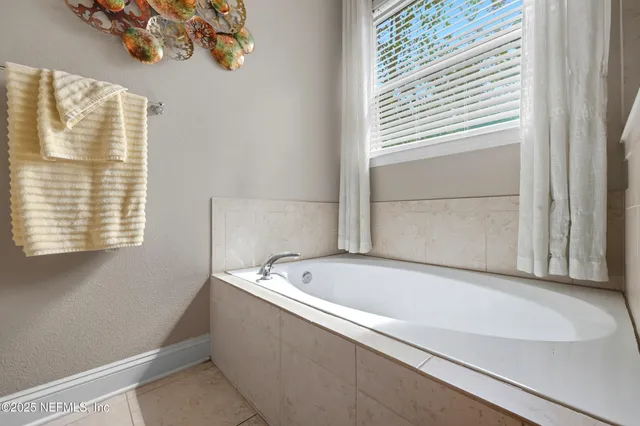 a bathroom with a bathtub and next to a window