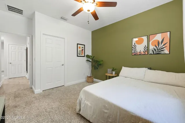 a bedroom with a bed and a painting on the wall