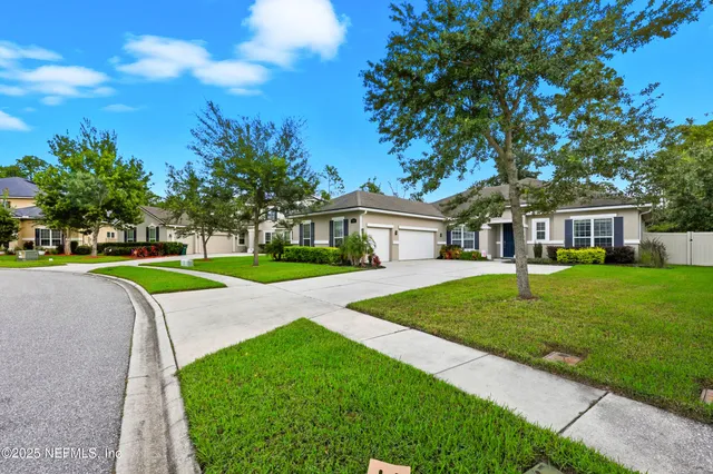 a front view of a house with a yard and trees
