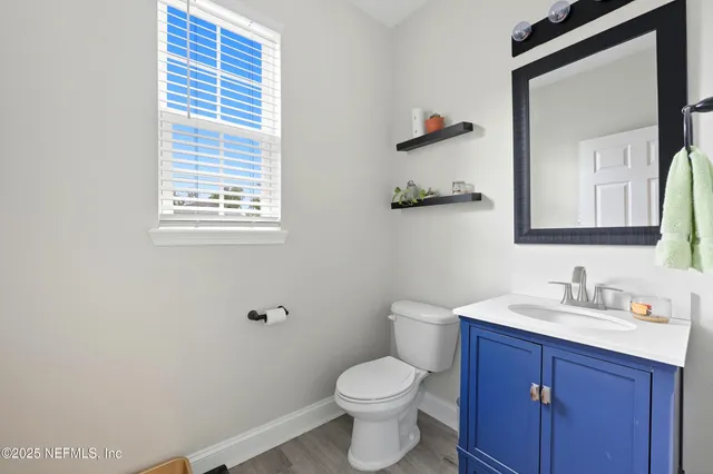 a bathroom with a toilet sink vanity and mirror
