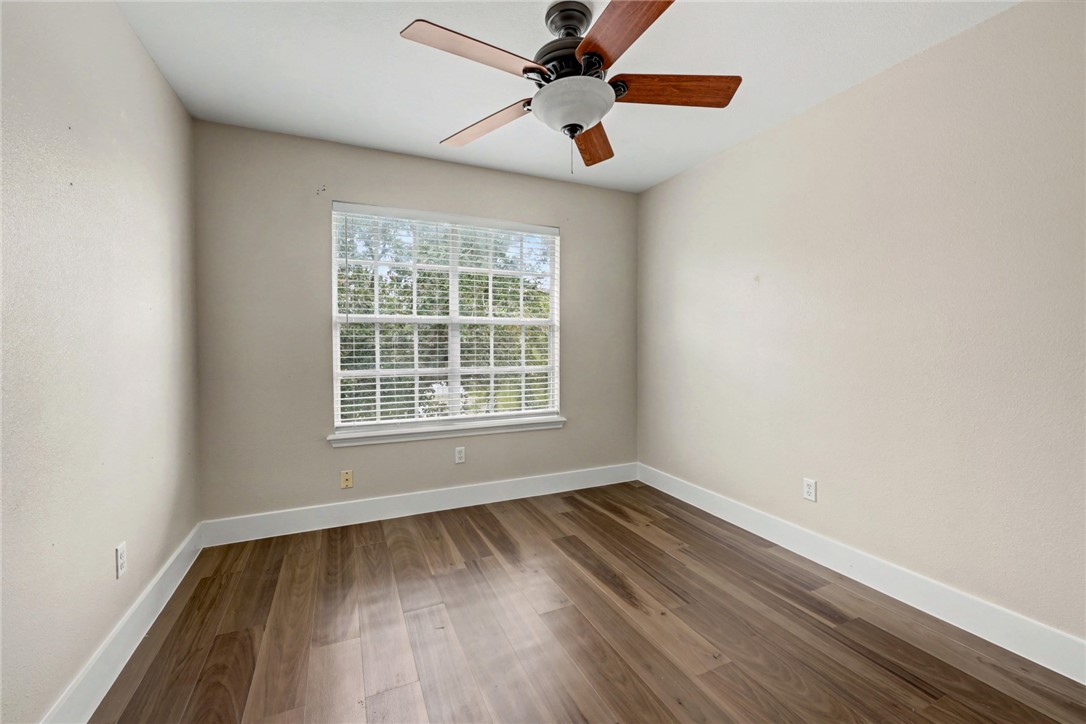 7541 Yorkshire Drive Corpus Christi, TX 78413 - Photo 28 of 32 an empty room with wooden floor fan and windows