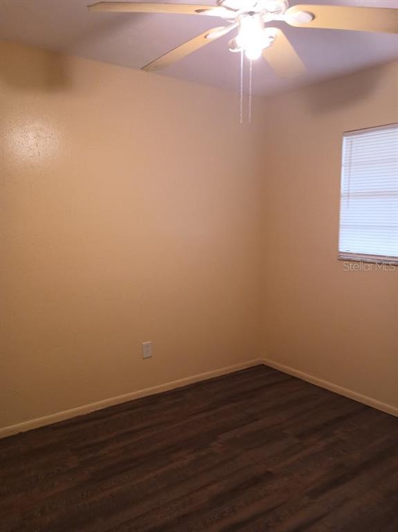 6726 Carnelian Avenue New Port Richey, FL 34653 - Photo 9 of 13 a view of a small space with wooden floor and a ceiling fan