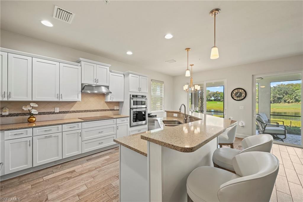 10231 Glastonbury Circle, Unit 101 Fort Myers, FL 33913 - Photo 4 of 35 a kitchen with stainless steel appliances granite countertop a sink and a refrigerator