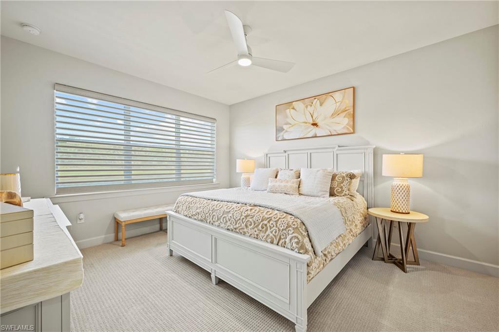 10231 Glastonbury Circle, Unit 101 Fort Myers, FL 33913 - Photo 9 of 35 a bedroom with a bed and a lamp on table