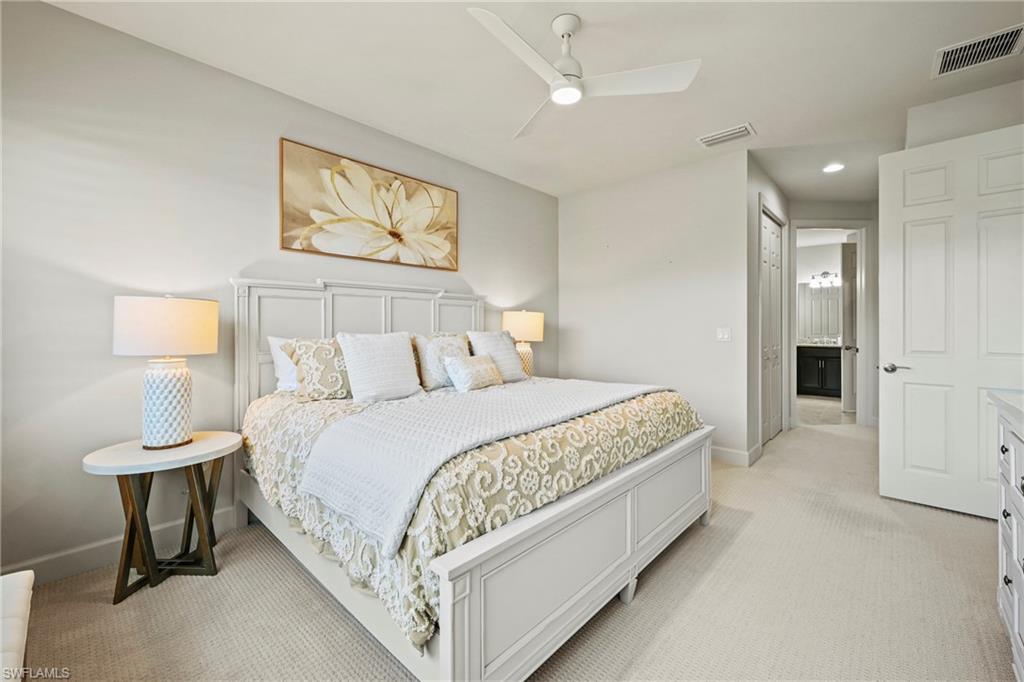 10231 Glastonbury Circle, Unit 101 Fort Myers, FL 33913 - Photo 10 of 35 a bedroom with a bed and a painting on the wall