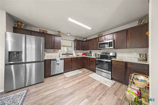 a kitchen with granite countertop stainless steel appliances and wooden cabinets