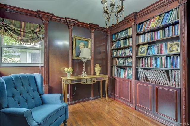a living room with furniture a bookshelf and a window