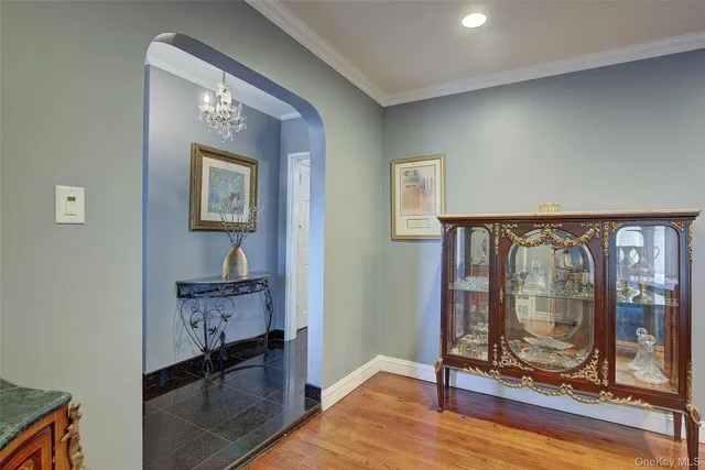 a view of a hallway with wooden floor and a bathroom