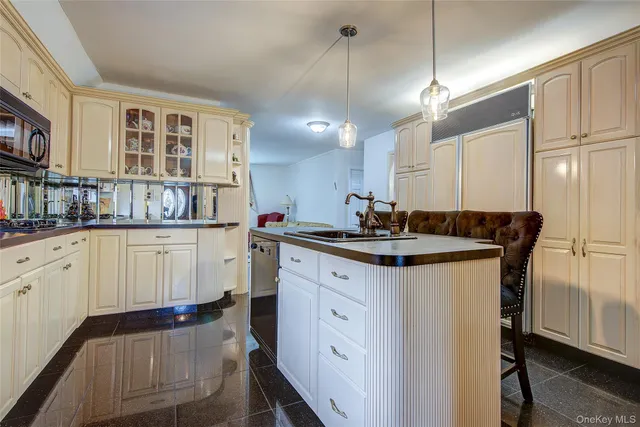 a kitchen with kitchen island granite countertop a sink cabinets and wooden floor