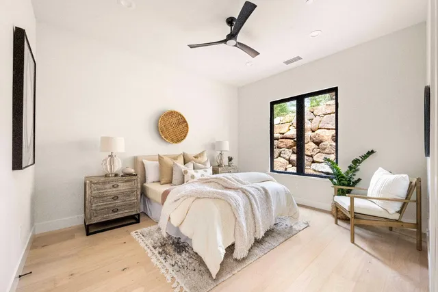 a bedroom with a bed a chandelier and a window