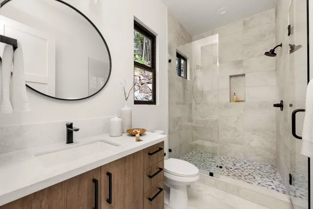 a bathroom with a sink a toilet and shower