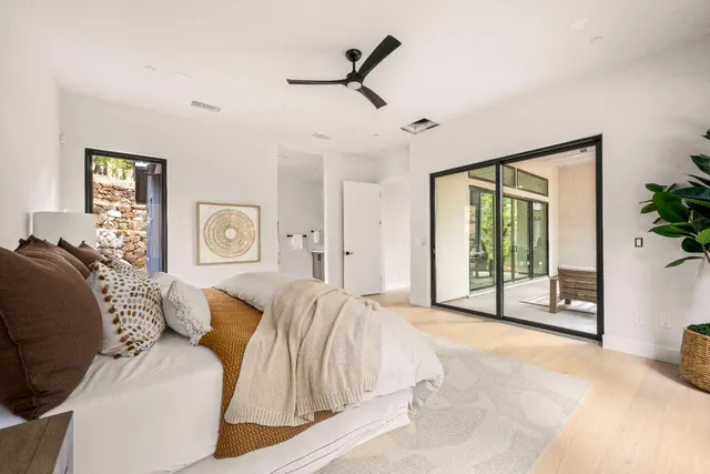 a spacious bedroom with a large bed and a chandelier