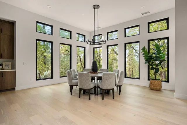 a view of a dining room with furniture large windows and wooden floor