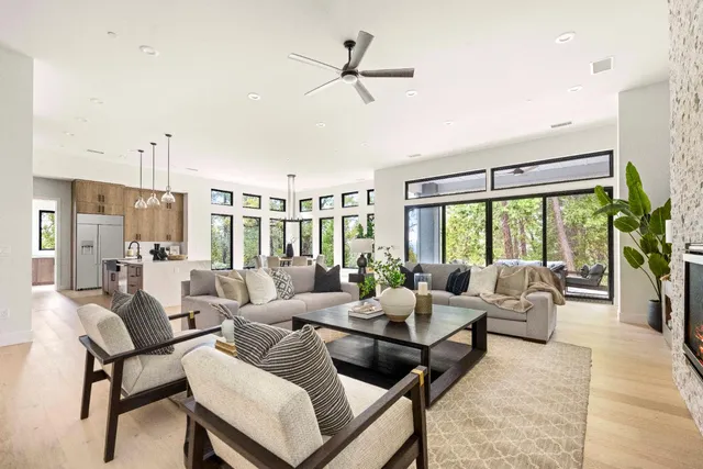 a living room with furniture ceiling fan and a large window