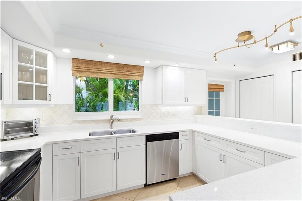 445 3rd Avenue South, Unit 102 Naples, FL 34102 - Photo 13 of 22 a kitchen with white cabinets and a window