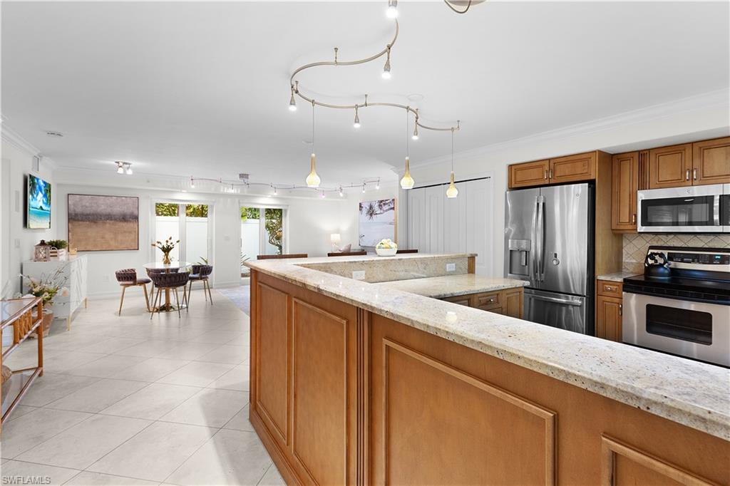 445 3rd Avenue South, Unit 102 Naples, FL 34102 - Photo 22 of 22 a large kitchen with a table and chairs