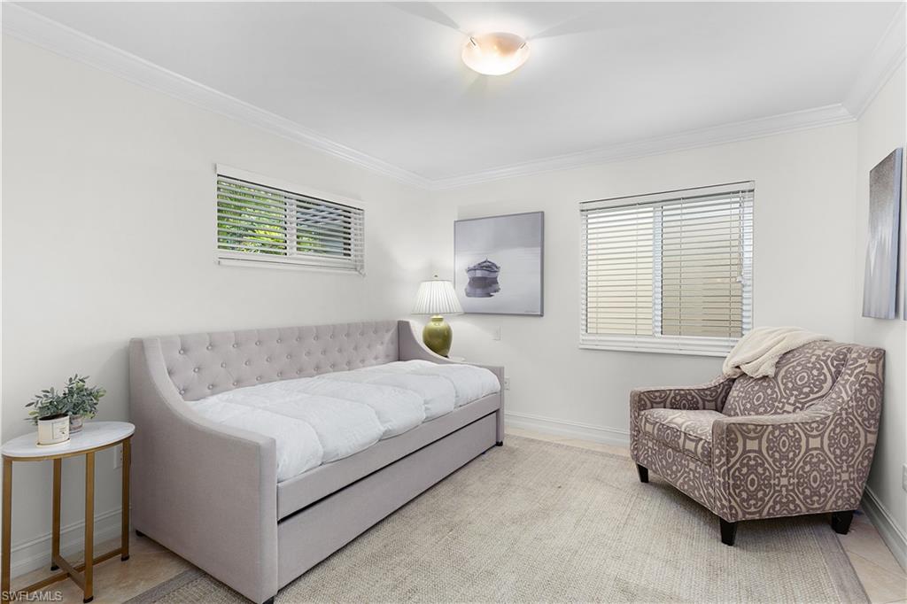 445 3rd Avenue South, Unit 102 Naples, FL 34102 - Photo 14 of 22 a bedroom with a bed and couch